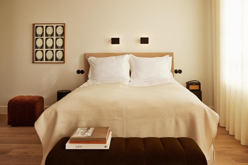 ein Schlafzimmer mit einem großen weißen Bett und zwei Büchern in der Unterkunft Mjólk Hotel in Reykjavík