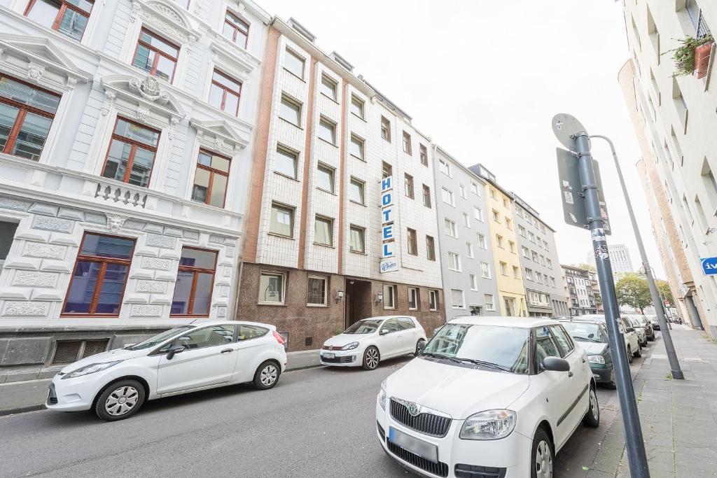 un grupo de coches estacionados en una calle de la ciudad en Hotel Windsor, en Colonia