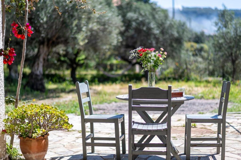 a table with two chairs and a table with flowers on it at Green Blue Kardamyli in Kardamyli