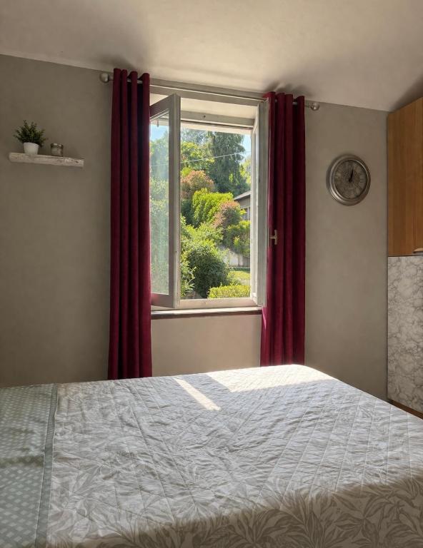 a bedroom with a bed and a window with red curtains at Pino Center in Pino Torinese