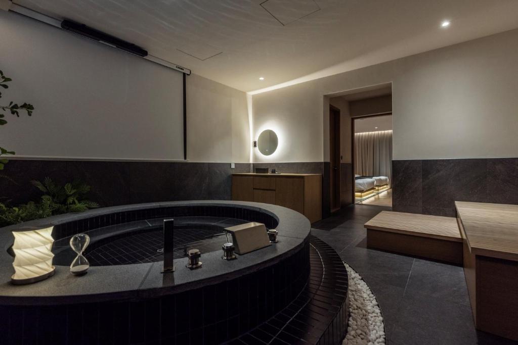 a bathroom with a bath tub in the middle at Anook Ryokan Hotel Daejeon Yuseong in Daejeon