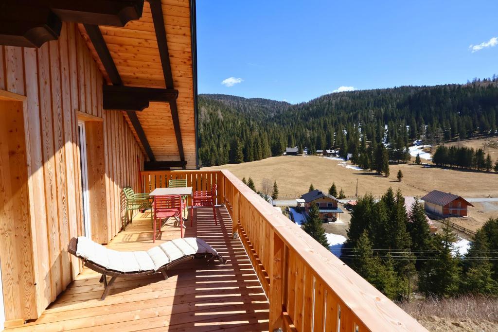 a wooden balcony with a table and chairs on a house at Claras Bergzeit in Flattnitz