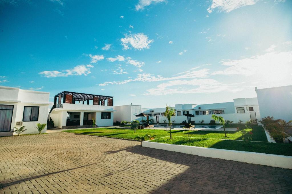 a row of white buildings with a blue sky at Nook Villas in Bagamoyo