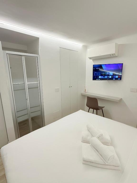 a white bedroom with a bed with two white towels at Colombo 365 in Civitanova Marche
