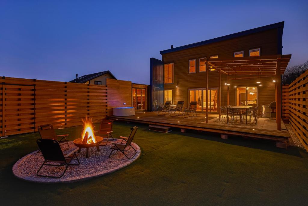 a backyard with a fire pit and a house at IZA moriyama in Moriyama