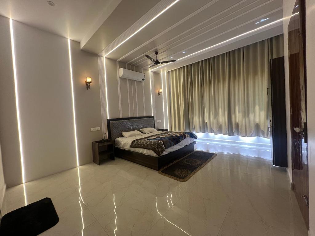 a bedroom with a bed and a large window at Hotel Plain A Quiet Stay in Mubārikpur