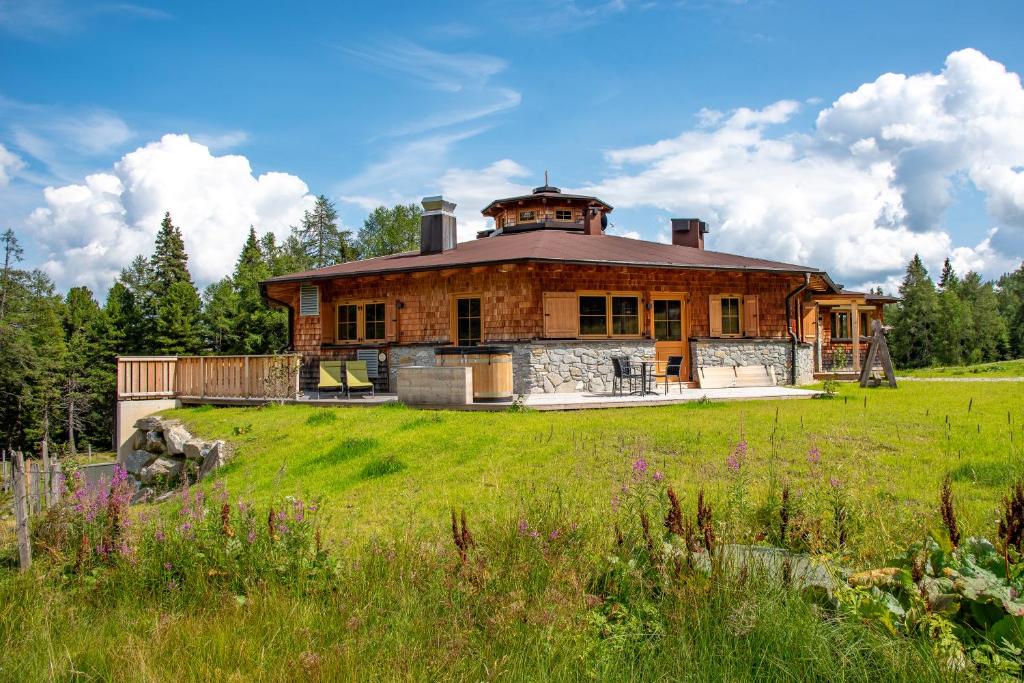 a large house on a grassy field in front at Bockspitze Deluxe Appartements in Hinterweisspriach