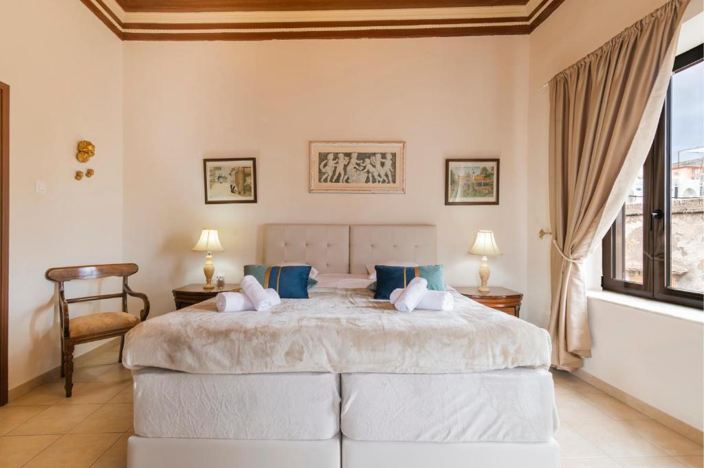 a bedroom with a large white bed with blue pillows at Kristina´s Apartments in Rhodes Town