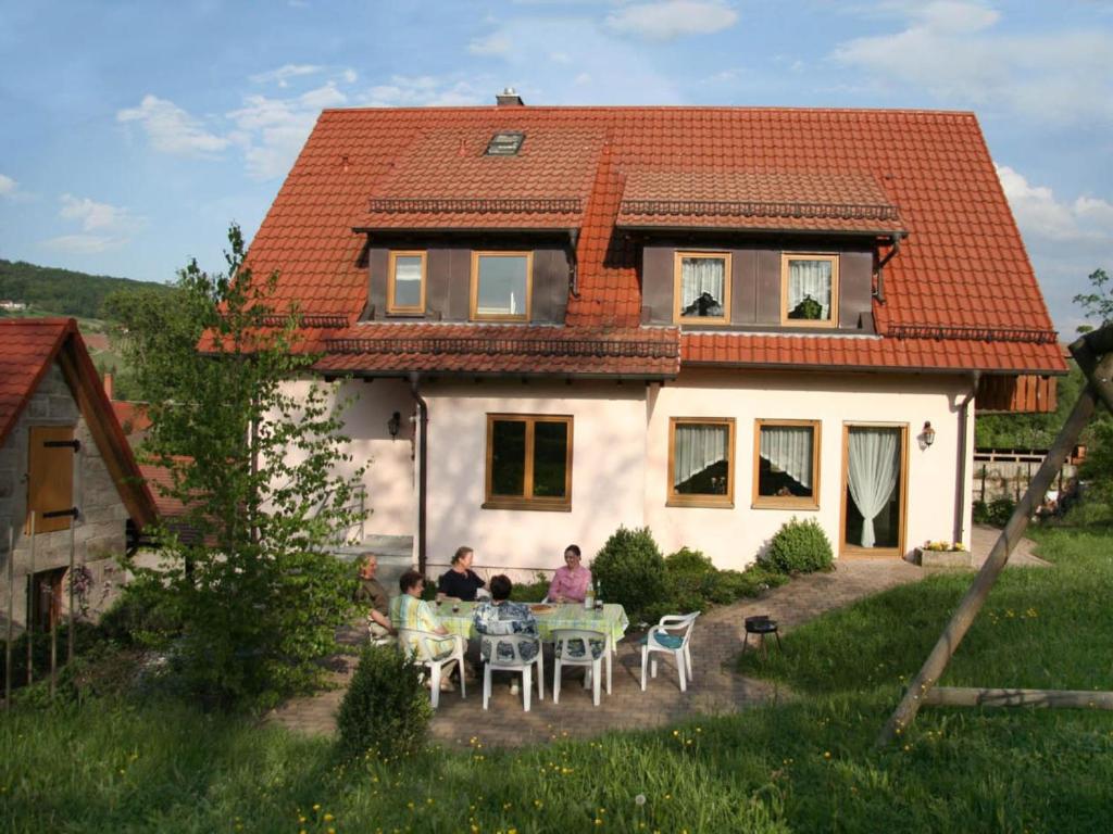 a group of people sitting at a table in front of a house at Haus am Limes in Pfedelbach