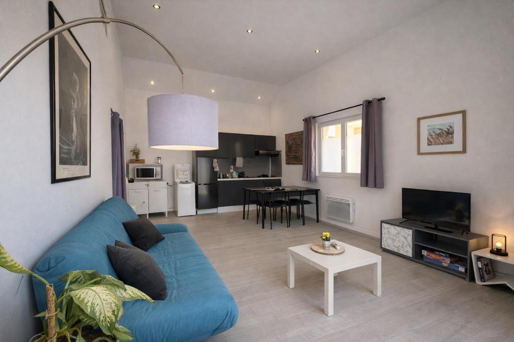 a living room with a blue couch and a table at La Maisonette à Lacrost in Lacrost