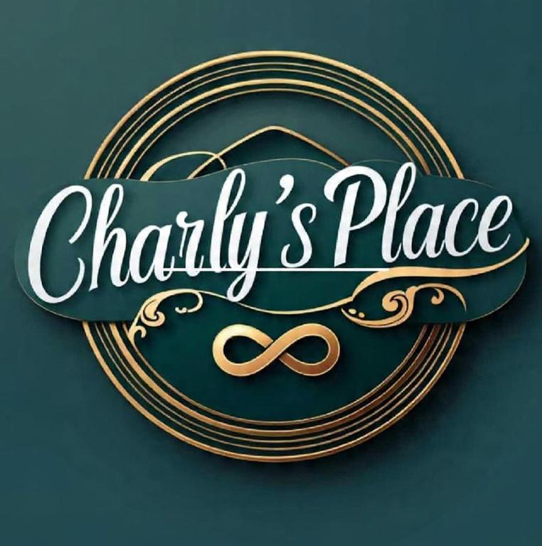 a gold and black sign with a pair of scissors at Charly`s Place in Rain