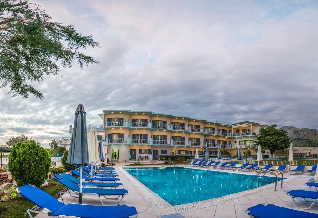 a resort with a pool and lounge chairs and a hotel at Cliff Bay Hotel by GHH in Paleros