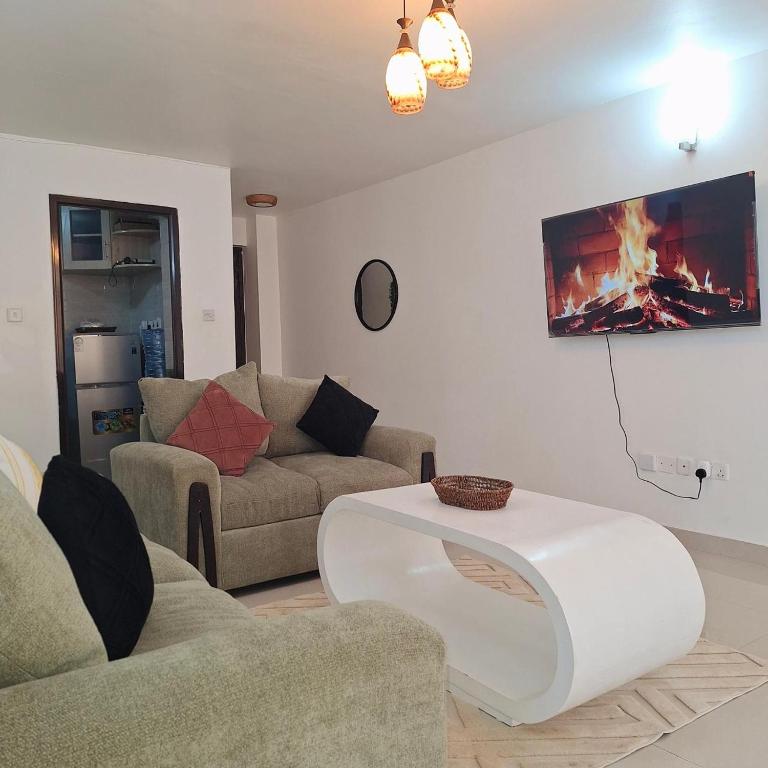 a living room with two couches and a fireplace at Zerani Homes in Ruaka