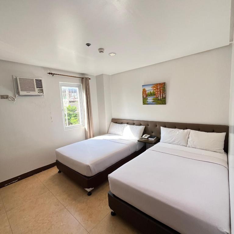 a room with two beds and a window at Hotel 801 in Cagayan de Oro