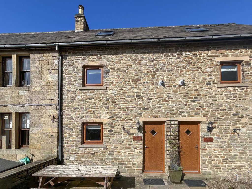a brick building with two doors and a bench in front at Ash Cottage - Ukc9266 in Hope