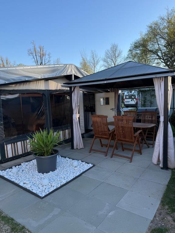 a patio with a table and chairs under a canopy at Campingwohnung am Silbersee in Freiburg in Freiburg im Breisgau