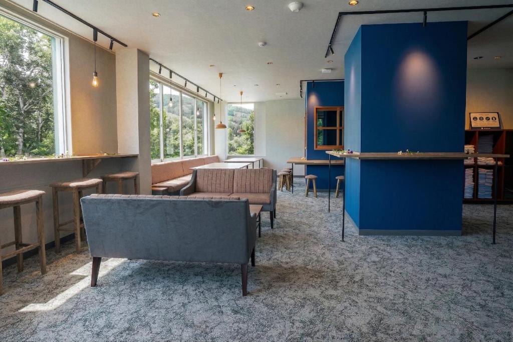 a waiting room with chairs and a blue wall at YuiLocalZao in Zaō Onsen