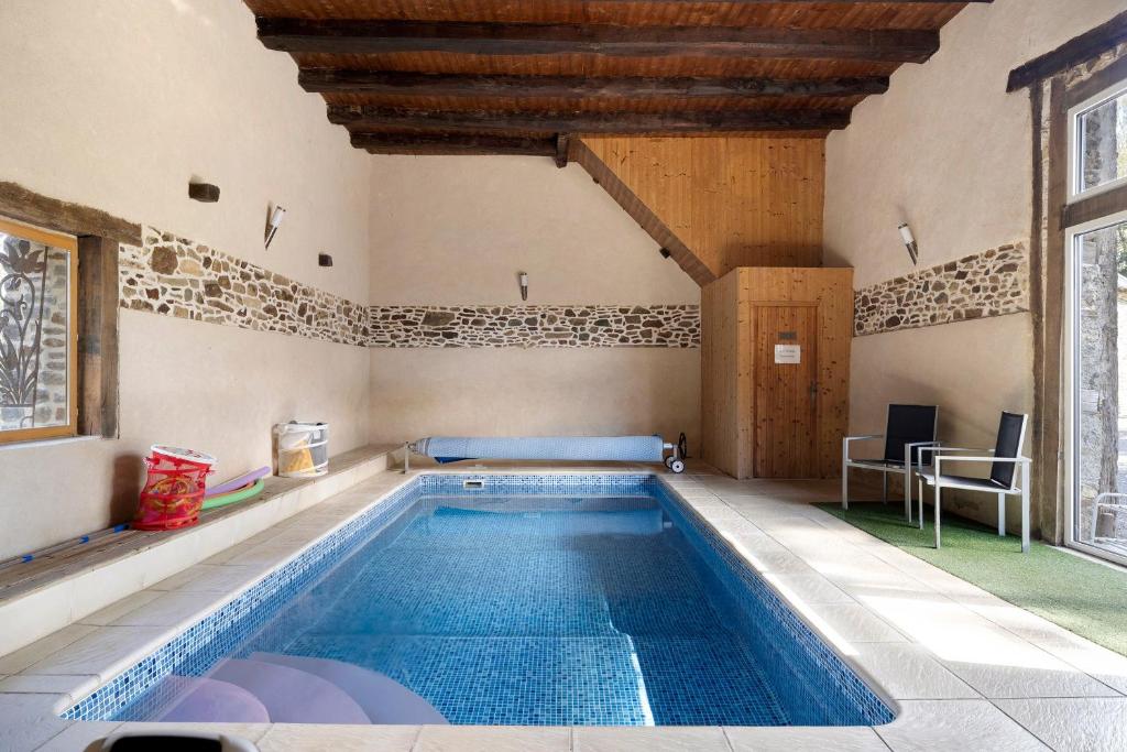 a large swimming pool in a room with at Le Fenil gîte avec piscine partagée in Saint-Thual