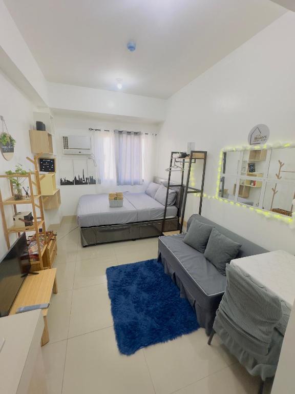 a living room with two beds and a couch at Ellain's Cozy Staycation-SMDC Green 2 Residences in Dasmariñas