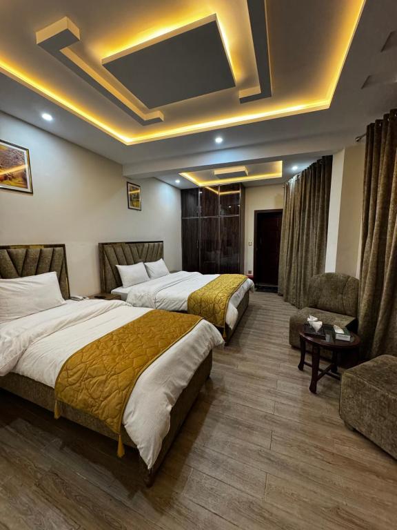 a hotel room with two beds and a couch at Hotel Summer Palace Murree in Murree