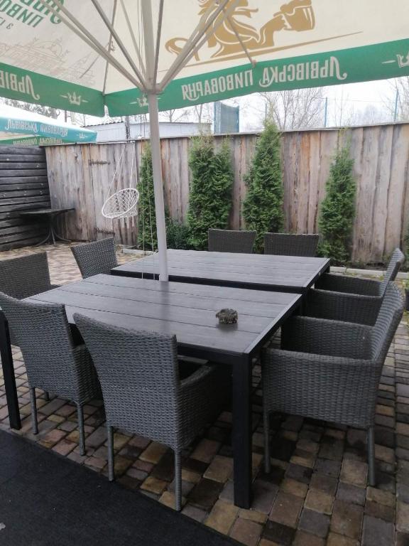 a wooden table with chairs and an umbrella at Котедж ,,Чудовий" з Чаном in Novaya Greblya