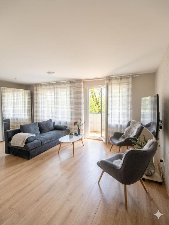 a living room with a couch and a table and chairs at Naomi apartaments in Saldus