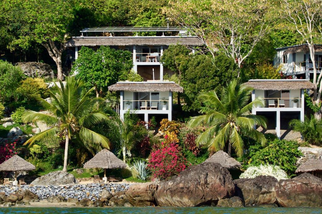 a resort from the water with trees and plants at Komba on the Rocks in Nosy Komba