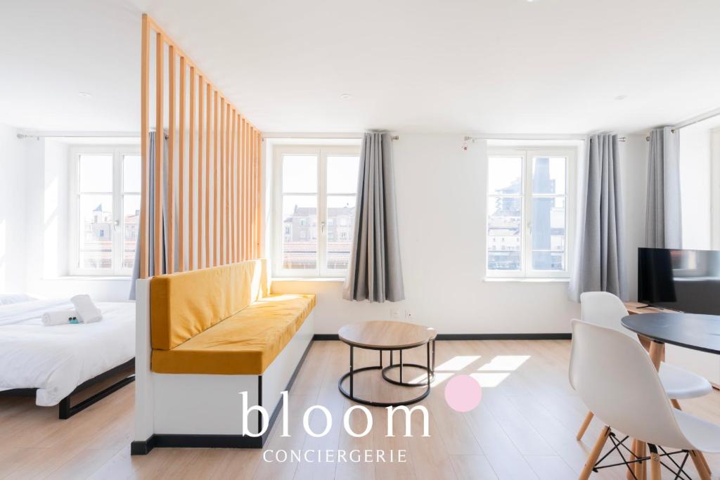 a room with a bed and a couch and a table at Le Soleil du Marché central in Nancy