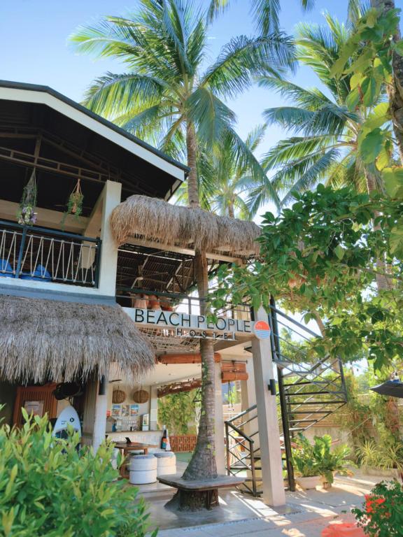 a resort with a sign in front of a building at Beach People Hostel Bantayan Island in Ocoy