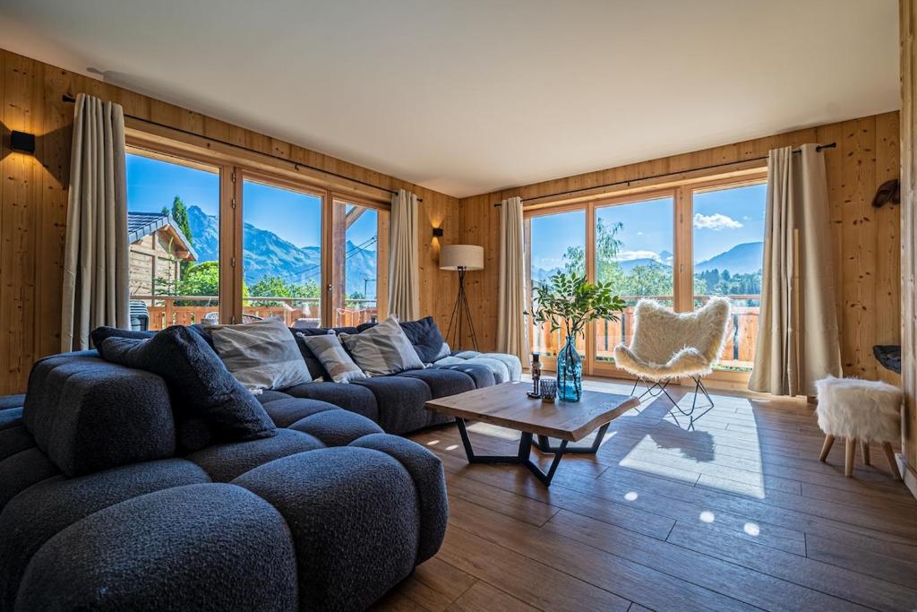 a living room with a blue couch and a table at Chalet Cocoon in Combloux