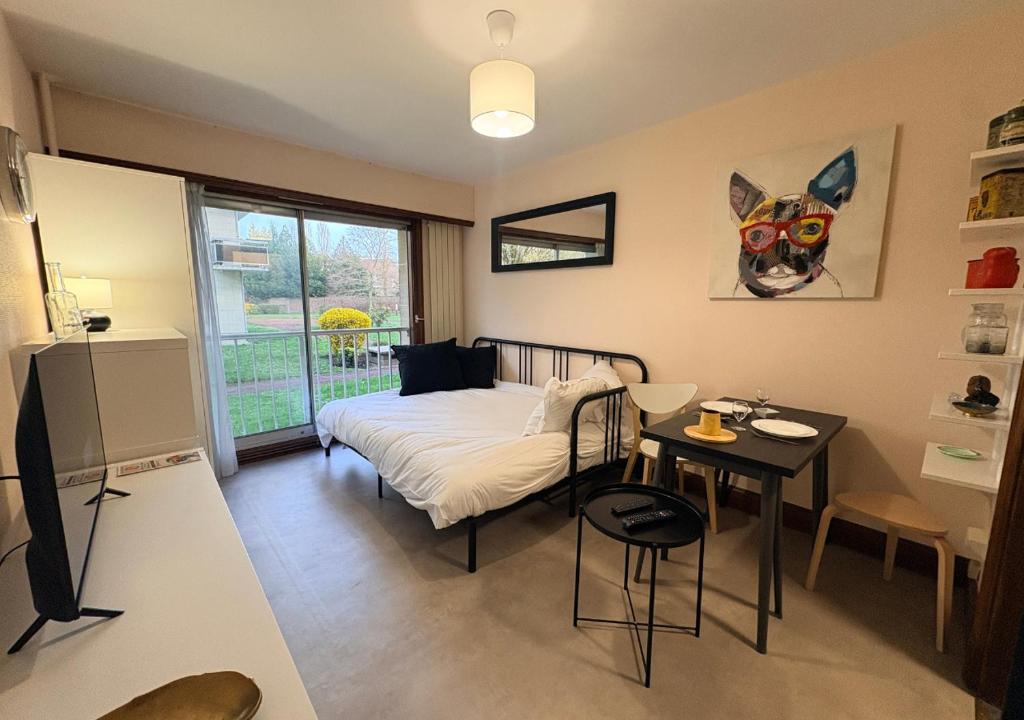 a bedroom with a bed and a table in it at Studio Cosy Carnot in Compiègne