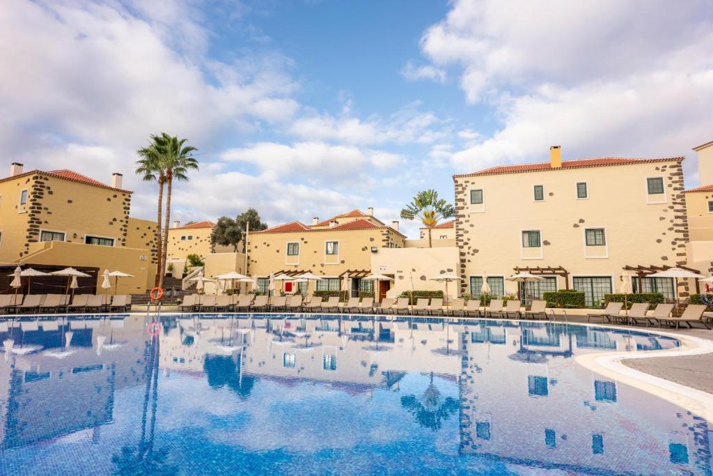 a large swimming pool with buildings in the background at GF Isabel in Adeje