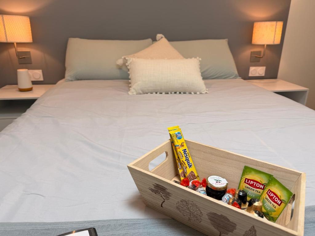 a wooden tray with food on a bed at L'Authentique Centre-ville Charme & Confort in Cognac