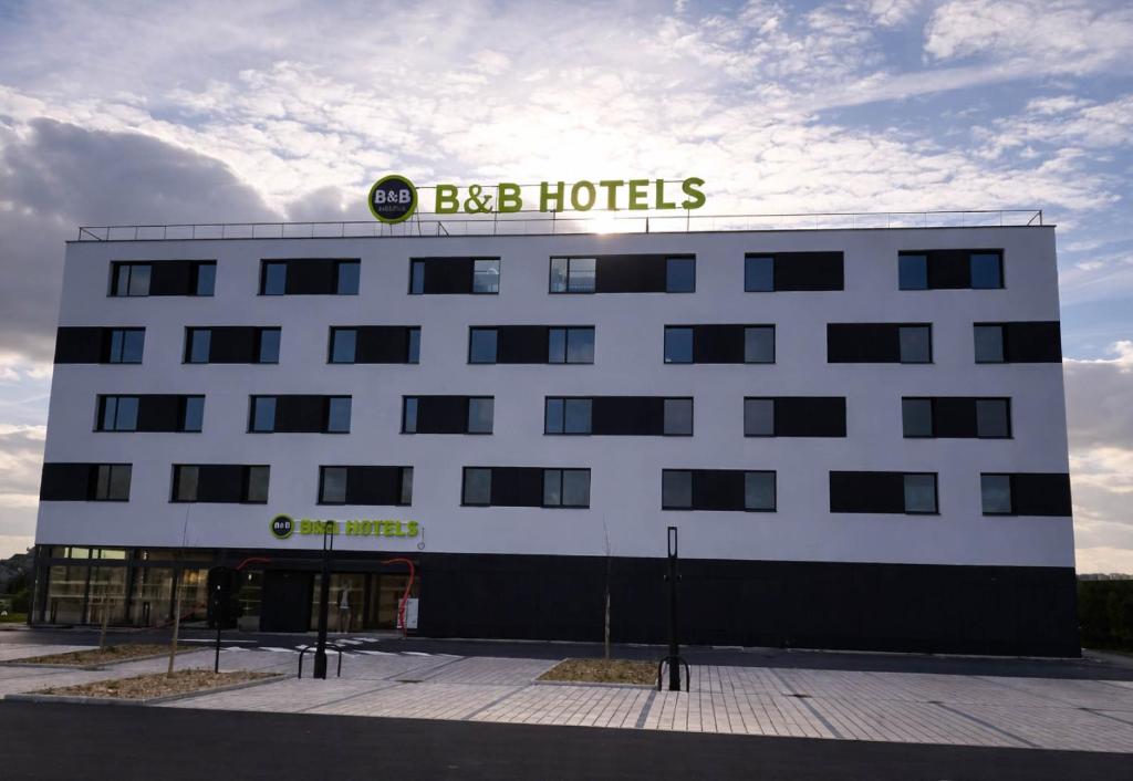 a building with a sign on the top of it at B&B HOTEL Rennes Liffré in Liffré