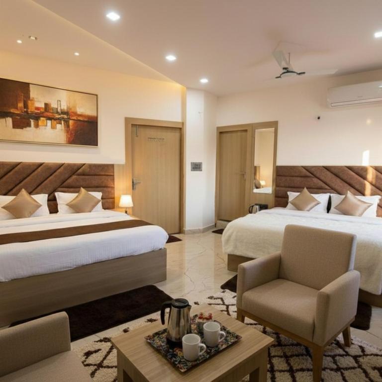 a hotel room with two beds and a chair at Shri Radha Kripa Dham in Rādha Kund
