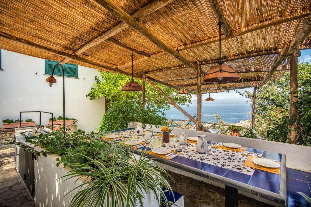 a dining table with a view of the ocean at GOCCE VILLAS - Sunshine Villa in Massa Lubrense