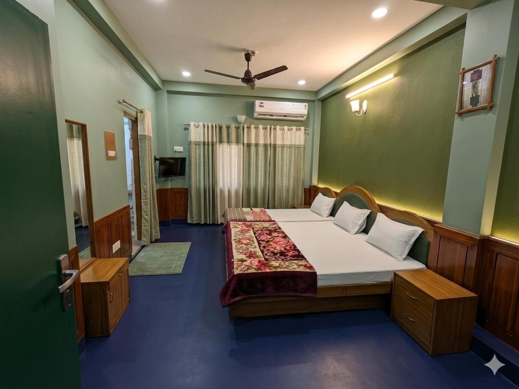 a bedroom with two beds in a green room at Hotel Neelkamal in Indore