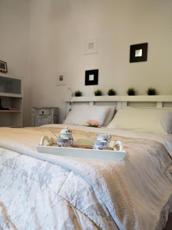 a bed with a tray with tea sets on it at Mirella's House in Padova