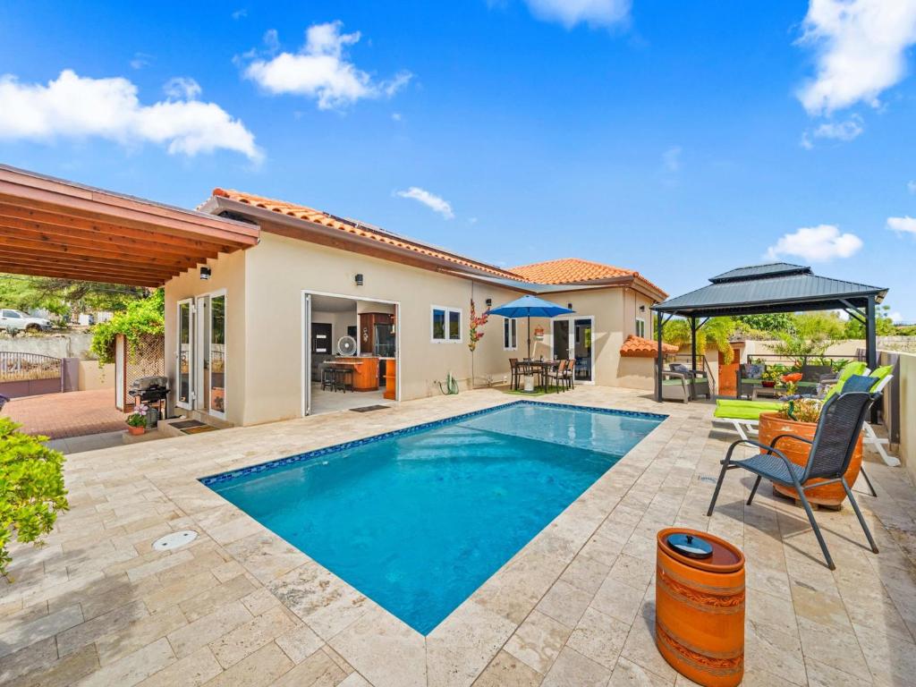a swimming pool in the backyard of a house at Villa Savannah in Savaneta