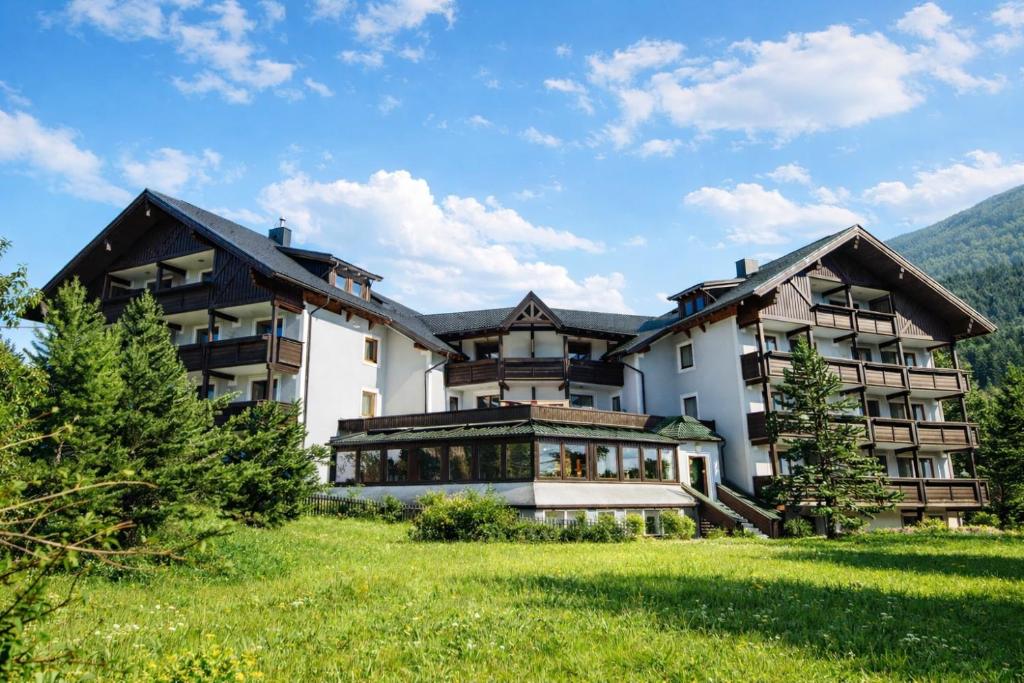 a large building with a green field in front of it at Apartments by GMS in Katschberghöhe