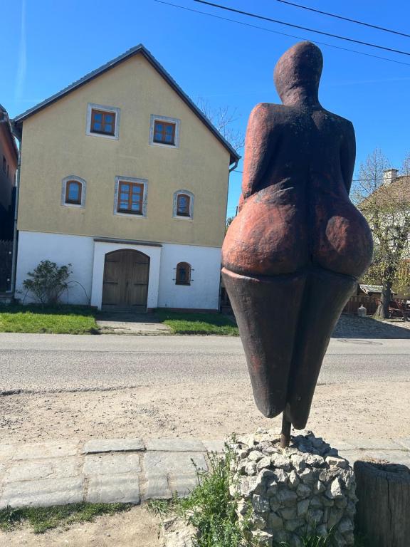 a statue of a woman sitting on the side of a street at Andělský sklípek in Dolní Věstonice