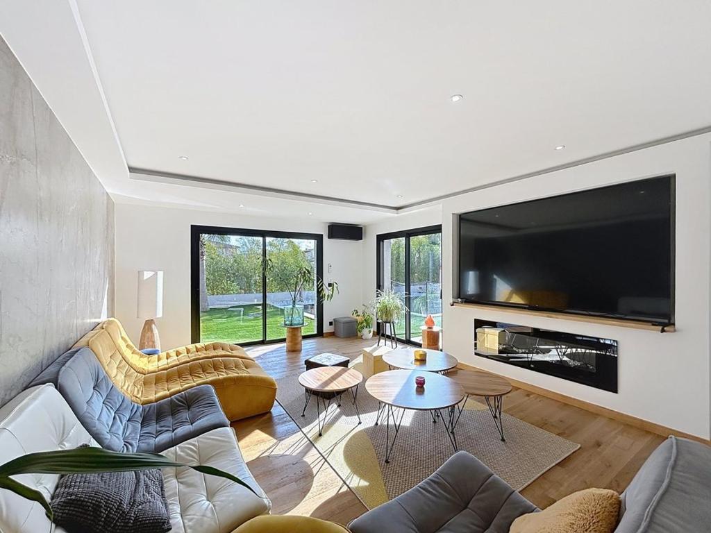 a living room with a large flat screen tv at Maison de prestige à Grimaud in Grimaud