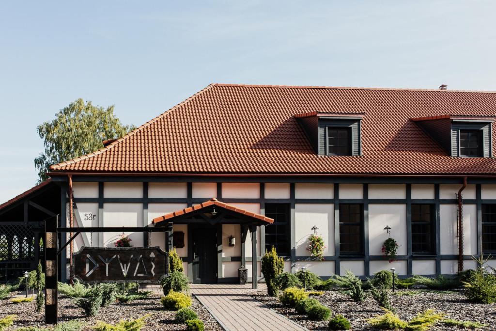 a house with a red roof at Viešbutis DYVAI in Kupiškis