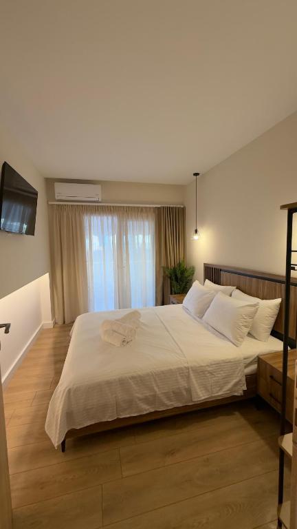 a bedroom with a large white bed with a window at Sweet Nest in Paralia Katerinis