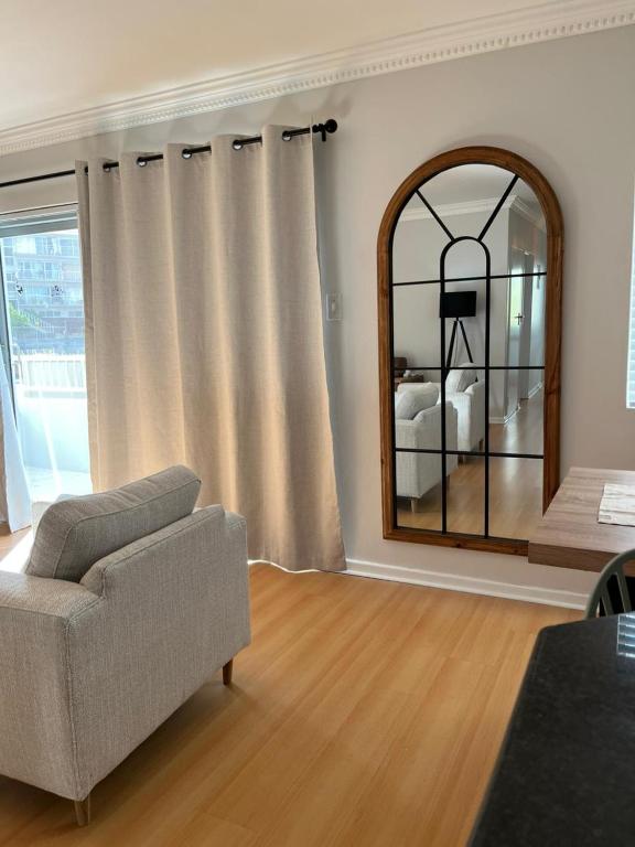 a living room with a couch and a mirror at The Little Cove in Strand