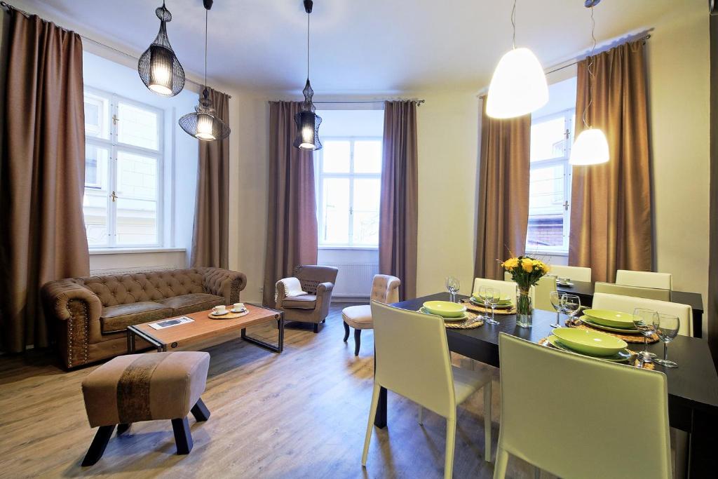 een eetkamer en een woonkamer met een tafel en stoelen bij DeLuxe Apartment in Praag