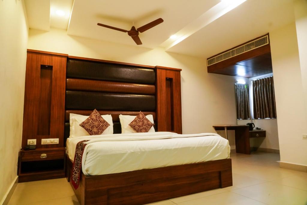 a bedroom with a large bed with a wooden headboard at Tree Inn Jubilee in Hyderabad