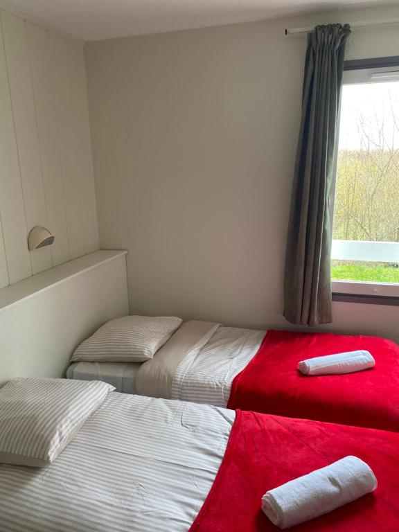 two beds in a room with a red blanket at Fast hôtel Troyes in Barberey-Saint-Sulpice