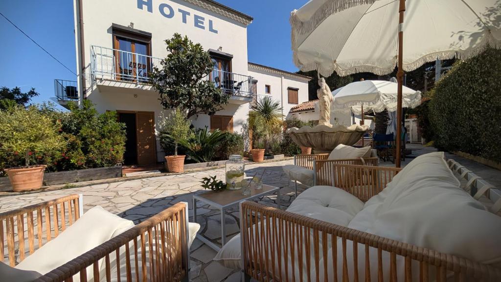 a hotel patio with chairs and an umbrella at Hotel La Bastide in Le Lavandou