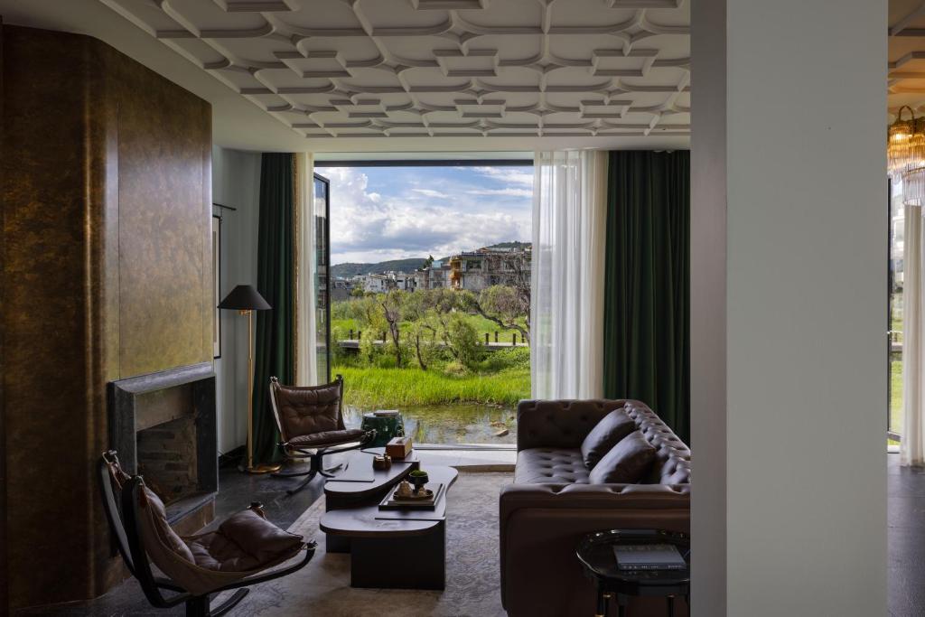 a living room with a couch and chairs and a fireplace at Arcadia Small courtyard in Dali Shuanglang